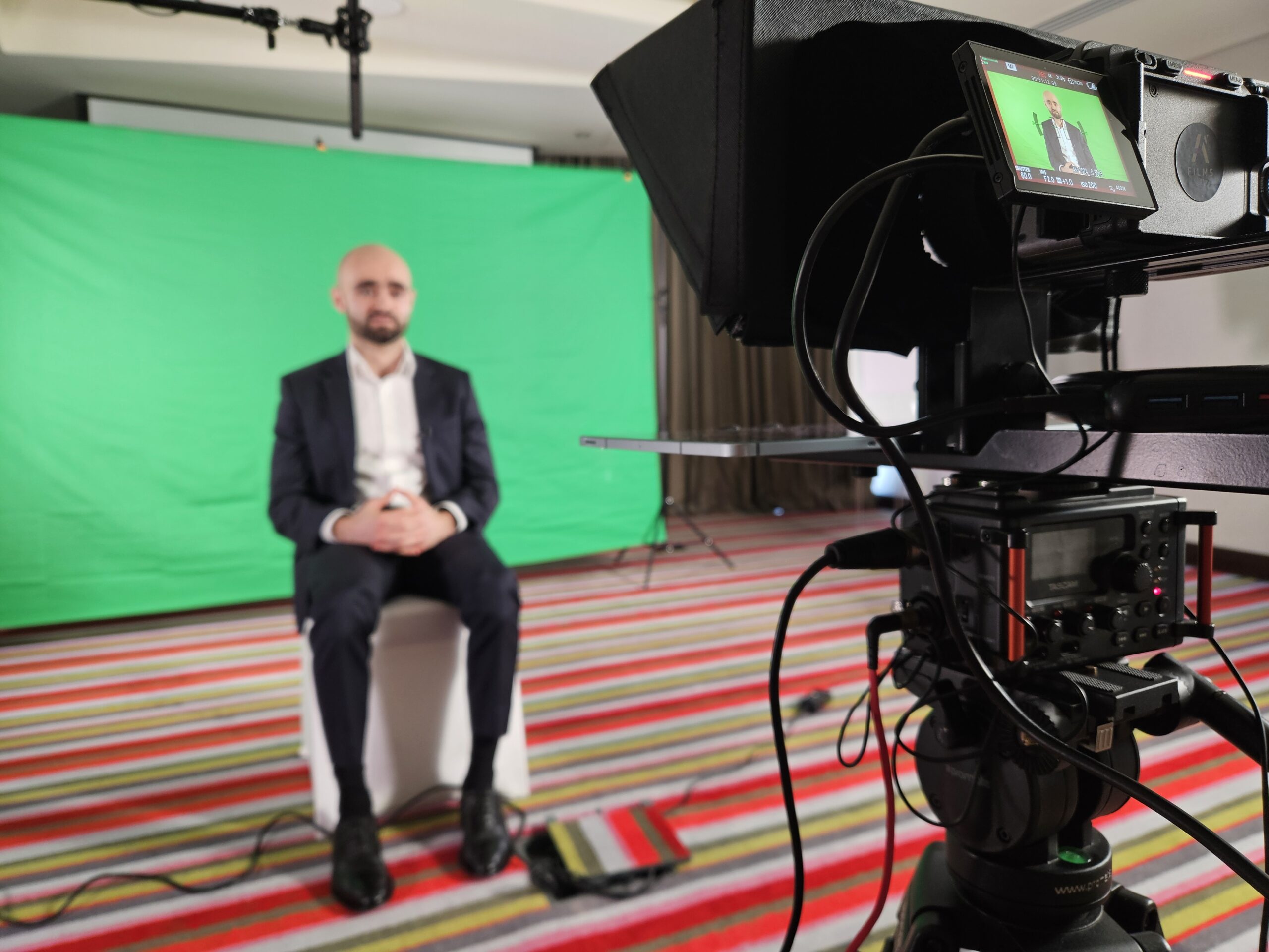 a photographer with his professional video production gear taking a shoot in a big shared space office room