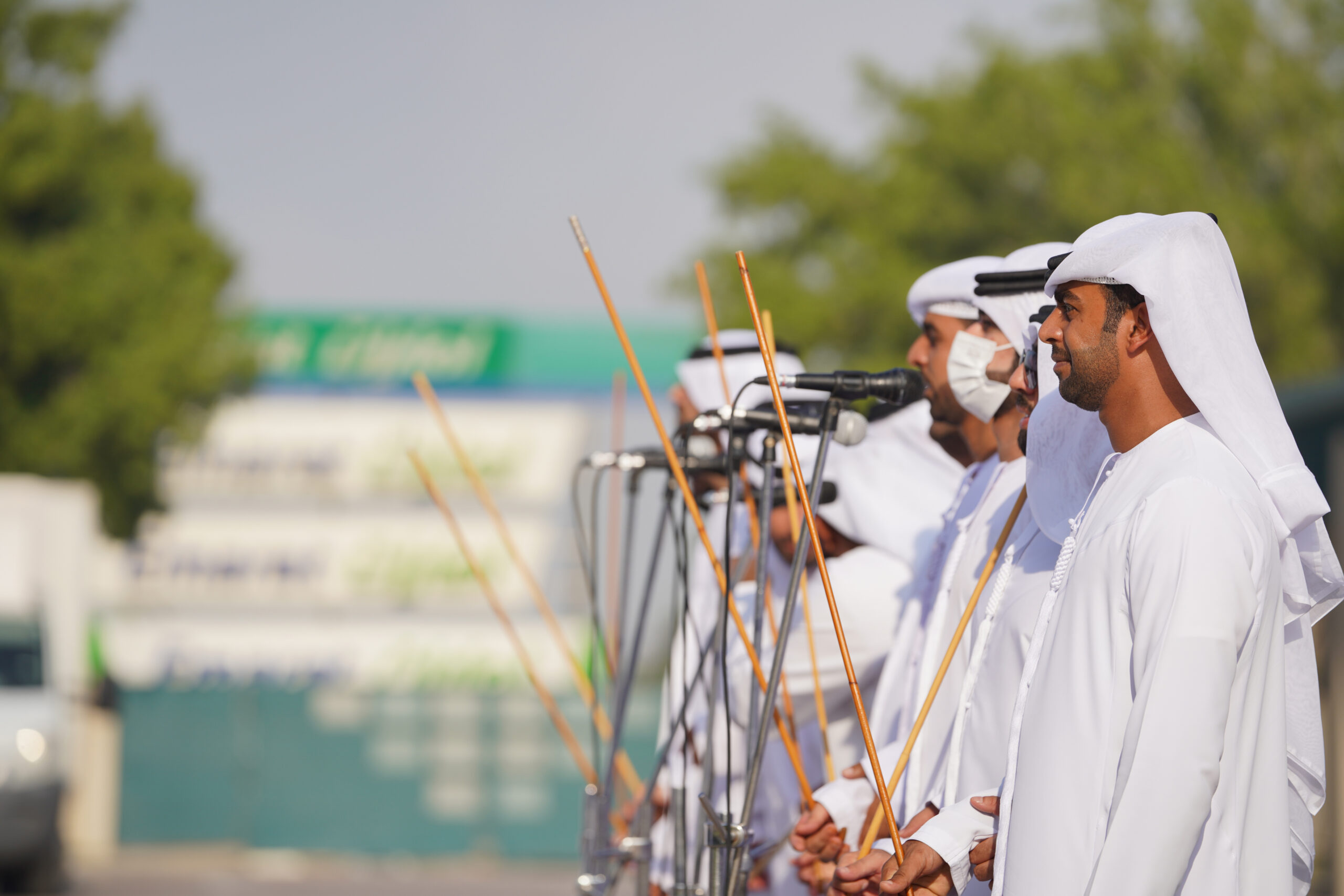 A group of people at a tech exhibition interacts with a booth displaying digital screens under the